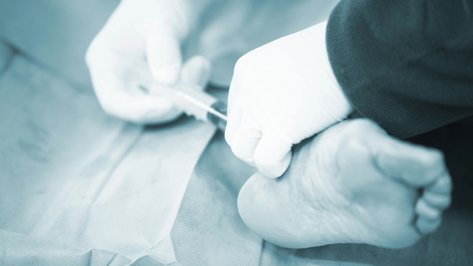 A person is cutting a foot with a pair of scissors at Princeton, NJ.