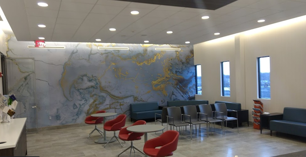 A waiting room with a large mural on the wall.